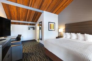 a hotel room with a bed and a flat screen tv at Days Inn by Wyndham Ukiah in Ukiah