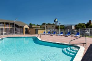 a swimming pool with blue chairs and a volley ball court at Days Inn by Wyndham Ukiah in Ukiah