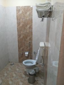 a bathroom with a white toilet in a room at Dwivedi Hotels Hotel Elena in Varanasi