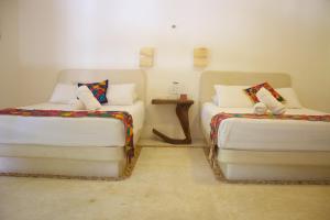 Postel nebo postele na pokoji v ubytování Casa Iguana Holbox - Beachfront Hotel