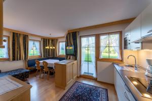 una cucina e un soggiorno con tavolo, cucina e sala da pranzo di Artitsch a Santa Cristina in Val Gardena