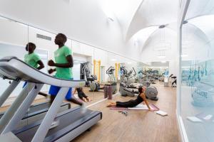 un gimnasio con la gente haciendo ejercicio en cintas de correr en Rivalta Hotel - Alfieri Collezione en Florence