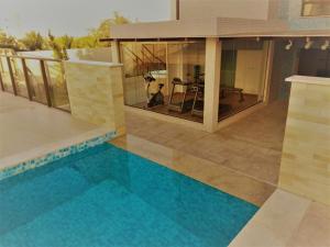 a house with a swimming pool in front of a house at Concept Tower Praia Apart in Aracaju