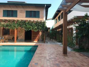 - une piscine en face d'une maison dans l'établissement Nai'a Suites, à Ubatuba