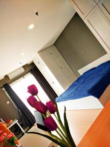a room with a bed and a vase of flowers at Kampar Champs Elysees, King Bed Studio unit 12A21 in Kampar