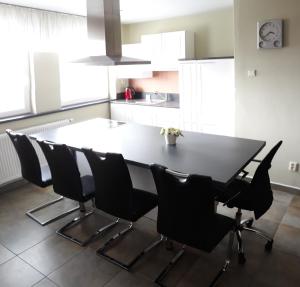a kitchen with a black table and chairs at Apartmán Lidická in Vracov