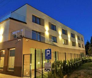 a white building with a parking sign in front of it at Hotel Sleep Wrocław in Wrocław