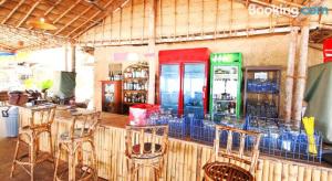 a restaurant with a bar with chairs and a soda machine at Blue Corner Beach Huts & Restaurant in Benaulim +18 photos
