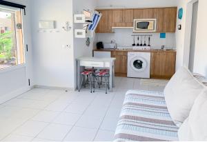 a small kitchen with a table and a microwave at La Primera Duna - Residencial Las Dunas in Corralejo