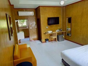 a bedroom with a bed and a desk with a television at Superkids Resort in Phitsanulok