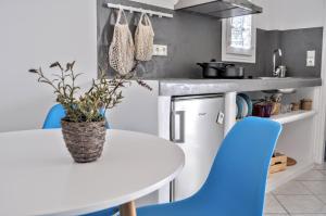 a kitchen with a white table and blue chairs at Casa Valeri Ι in Naxos Chora