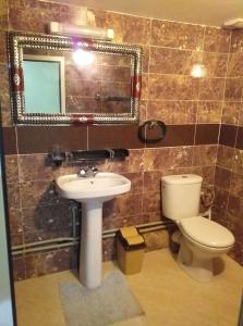 een badkamer met een toilet, een wastafel en een spiegel bij Bio Palace Hotel in Tinerhir