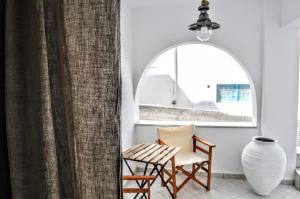 a room with a chair and a table and a window at Casa Valeri I - Charming Cycladic Studio in Naxos Town in Naxos Chora