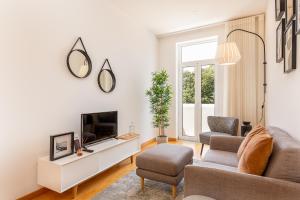 un soggiorno con divano e TV di YOUROPO - Cosy a Porto