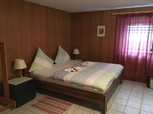 a bedroom with a bed and two lamps and a window at Ferienwohnung-Birlenbach in Birlenbach