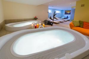 a large bath tub in a bathroom with a couch at Casa Della Luce Apartments by Zermatt Premium Apartments in Zermatt +108 photos