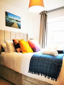 una cama con almohadas coloridas en una habitación en Lovely Holiday Home in Birmingham City Center 3 Bedrooms House By HF Group, en Birmingham