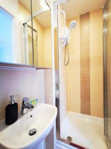 y baño con lavabo y ducha. en Lovely Holiday Home in Birmingham City Center 3 Bedrooms House By HF Group, en Birmingham