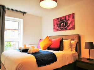 1 dormitorio con 1 cama grande y almohadas coloridas en Lovely Holiday Home in Birmingham City Center 3 Bedrooms House By HF Group, en Birmingham