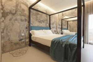 a bedroom with a canopy bed and a mirror at Hedoné Design Experience B&B in Agrigento