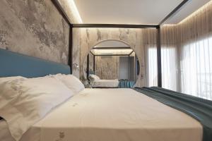 a bedroom with a large bed and an archway at Hedoné Design Experience B&B in Agrigento
