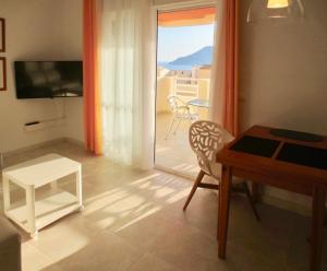 uma sala de estar com uma mesa e vista para uma varanda em Rubino em Calpe