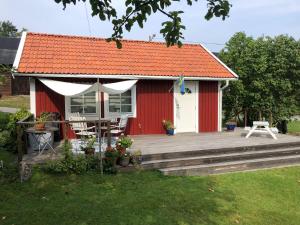 a red shed with a deck and a table and chairs at Fårbo in Gissebo +4 photos