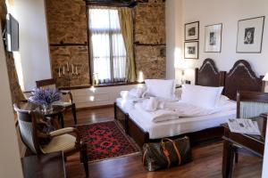 sypialnia z 2 łóżkami, stołem i krzesłami w obiekcie Boutique Hotel Palea Poli w mieście Nausa