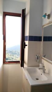 a bathroom with a sink and a window at Stellaria casa vacanze in montagna panorama stupendo Sardegna in Seùlo