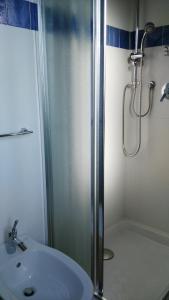 a shower with a glass door next to a white sink at Stellaria casa vacanze in montagna panorama stupendo Sardegna in Seùlo +50 photos
