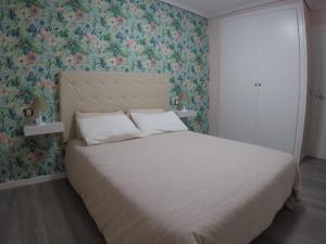 sypialnia z łóżkiem i tapetą w kwiaty w obiekcie El Rincón de Celia w mieście Graus