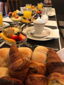 a table topped with plates of pastries and fruit at Cuerne bed&breakfast in Kuurne