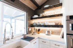 a kitchen with white cabinets and a sink and a window at Moon Ranch - a gateway to Yosemite in Mariposa