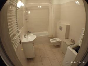 Baño blanco con lavabo y aseo en 1090 Śmiałego 38 - Tanie Pokoje w Apartamencie - samodzielne zameldowanie - self check in, en Poznan