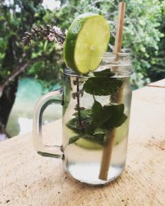 a glass mug filled with a drink with a slice of lime at Pachamaya River Hostel in Lanquín