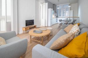 salon z kanapą i stołem w obiekcie Apartamentos Las Musas de Cadiz w Kadyksie
