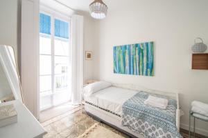biała sypialnia z łóżkiem i oknem w obiekcie Apartamentos Las Musas de Cadiz w Kadyksie