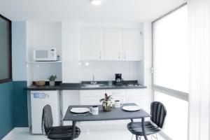 a kitchen with a table and two chairs and a microwave at Privada de Horacio 18 Residences in Mexico City