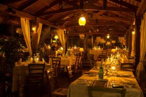 un restaurante con mesas blancas, sillas y luces en Villa Kololo en Kampala