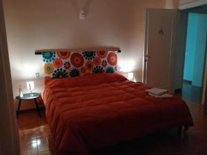 een slaapkamer met een groot bed en een rood dekbed bij Villetta dei tramonti in San Feliciano