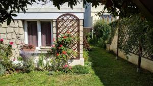 uma casa com um jardim com flores e uma janela em Appartement les Acacias em Clamart