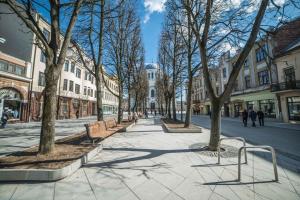 a street with benches and trees in a city at Deluxe Apartments by Hostlovers in Kaunas