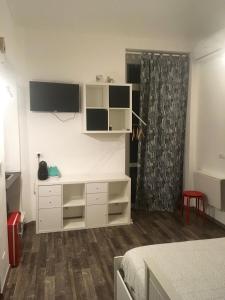 een slaapkamer met een witte dressoir en een tv aan de muur bij VanchigliArt Apartment in Turijn