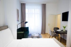 Schlafzimmer mit einem Bett, einem Tisch und Stühlen in der Unterkunft Studio Apartments Naschmarkt - Mai's Apartments - Naschmarkt by Arbio in Wien