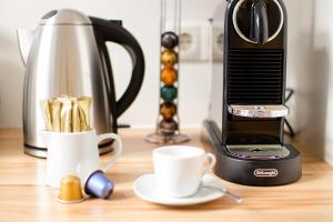 a coffee maker and cups on a wooden table at Studio Apartments Naschmarkt - Mai's Apartments - Naschmarkt by Arbio in Vienna