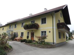 une maison jaune avec des fleurs sur son côté dans l'établissement Ferienwohnung Heimberger - Appartement 2, à Sölling