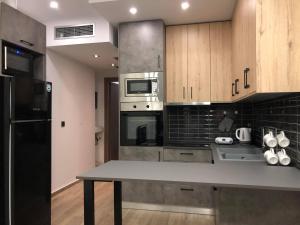 a kitchen with stainless steel appliances and wooden cabinets at M+V apartment in Alexandroupoli