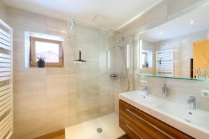 une salle de bain avec un lavabo et une douche dans l'établissement Biobauernhof AUBAUER, à Grossarl 14 autres photos