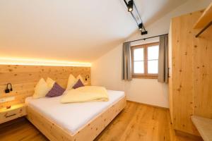 a bedroom with a large white bed with a window at Biobauernhof AUBAUER in Grossarl