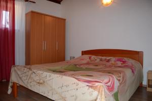 a bedroom with a bed and a wooden cabinet at Apartment Duerose in Buje